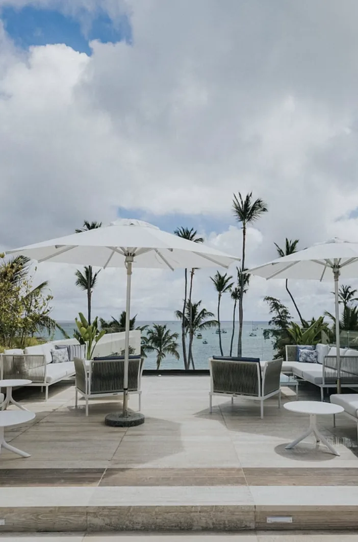 Terraza con sombrillas blancas y el mar al fondo